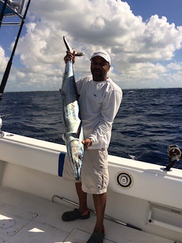 Ty holding a catch aboard a fishing boat on open water
